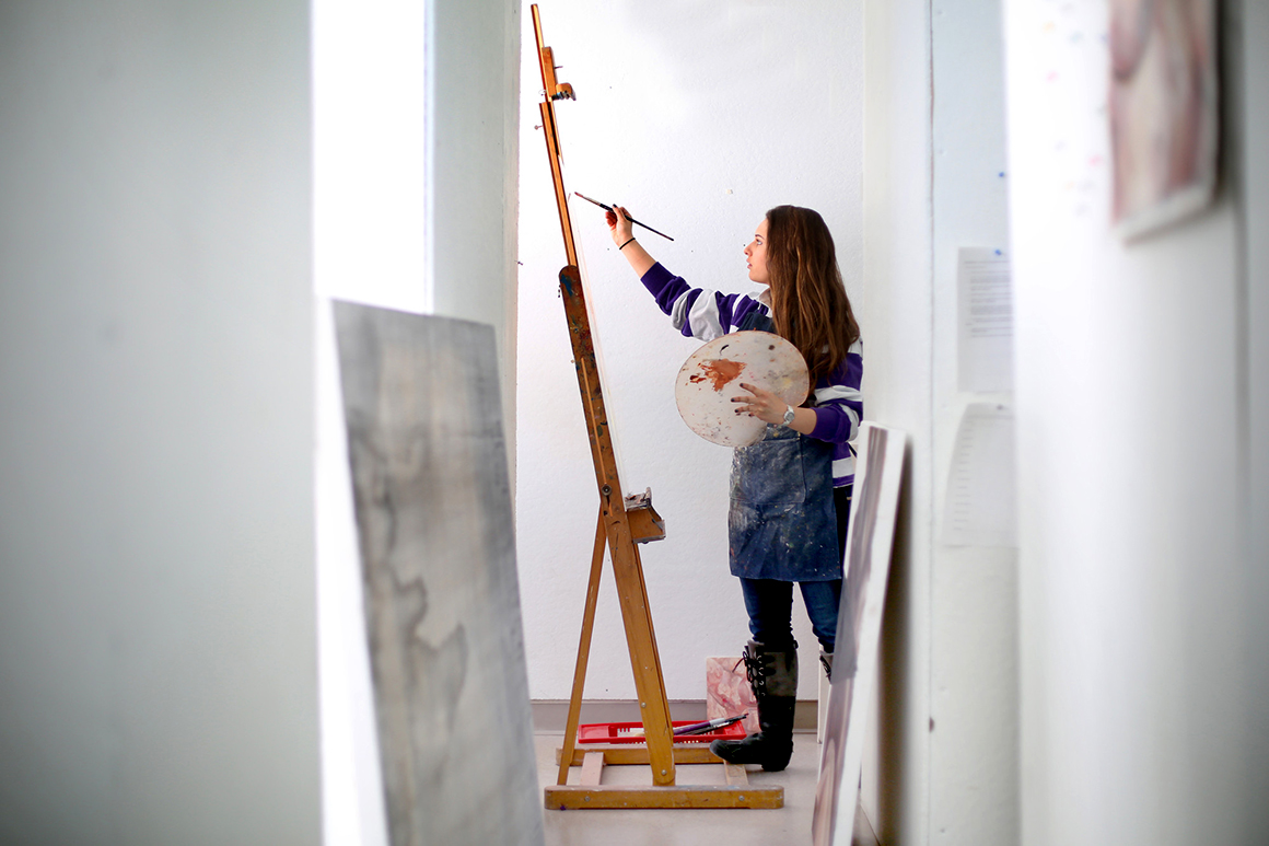 Student painting an an easel 