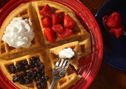 Belgian waffle with whipped cream, strawberries, blueberries and maple syrup.