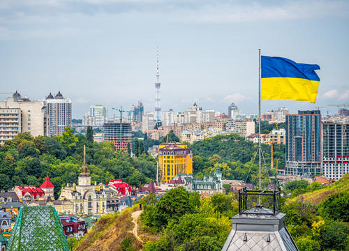 cityscape of Kiev and Ukrainian flag waving in the wind