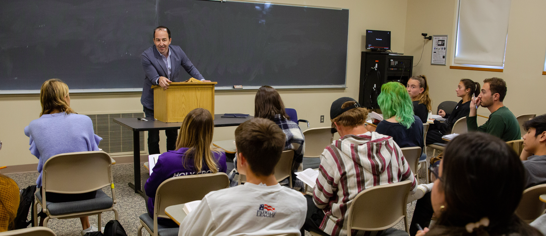 A professor from the English department standing before a classroom of students.