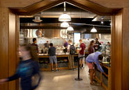 Students inside the Kimball Dining Hall servery waiting at various stations for food.