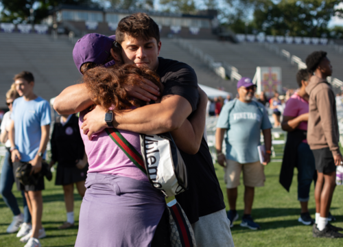 Mother and son hug on Fitton field during move-in day 2024