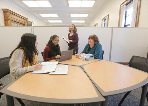 Center for Writing Director Laurie Ann Britt-Smith, far right, and Associate Director Kristina Reardon, standing, work with students on their writing