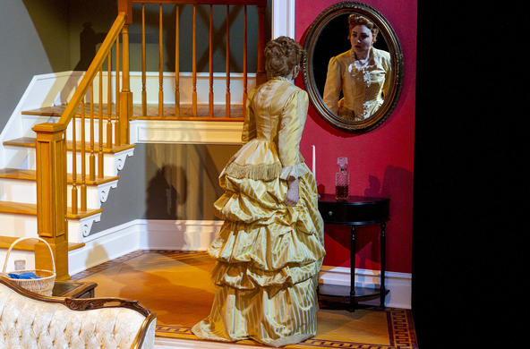 Catherine looks at herself in the parlor mirror.