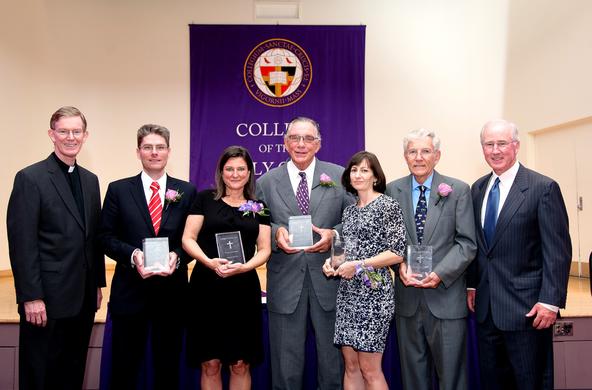 Sanctae Crucis award recipients holding their award flanked by Fr. Boroughs and John Mahoney '73, chair of board of trustees