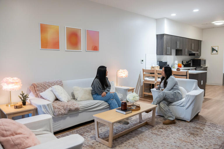Students sit in the living room of their townhouse on campus