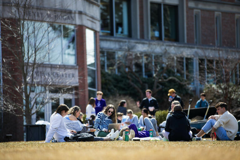 Students sitting in Hogan courtyard at springtime