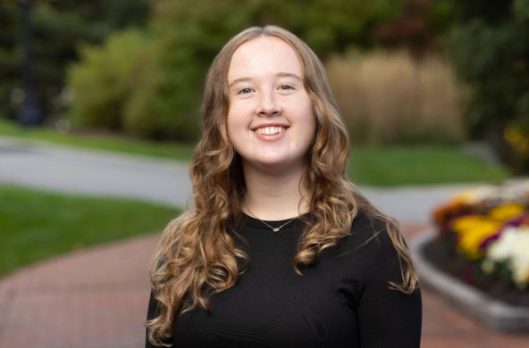 a young woman in a black shirt smiling at the camera