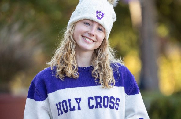 young woman in a holy cross sweater and hat