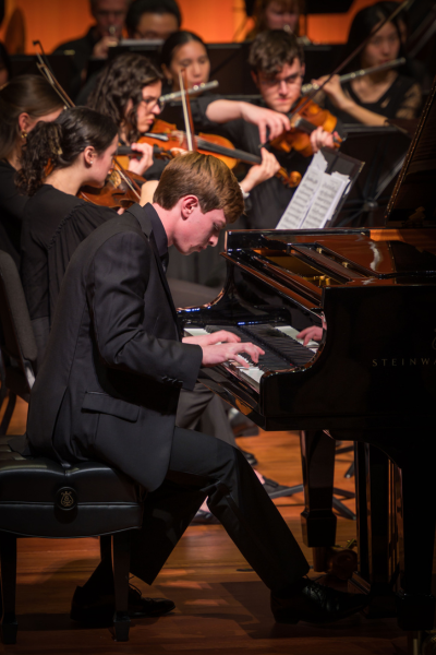 young man playing piano in a concert