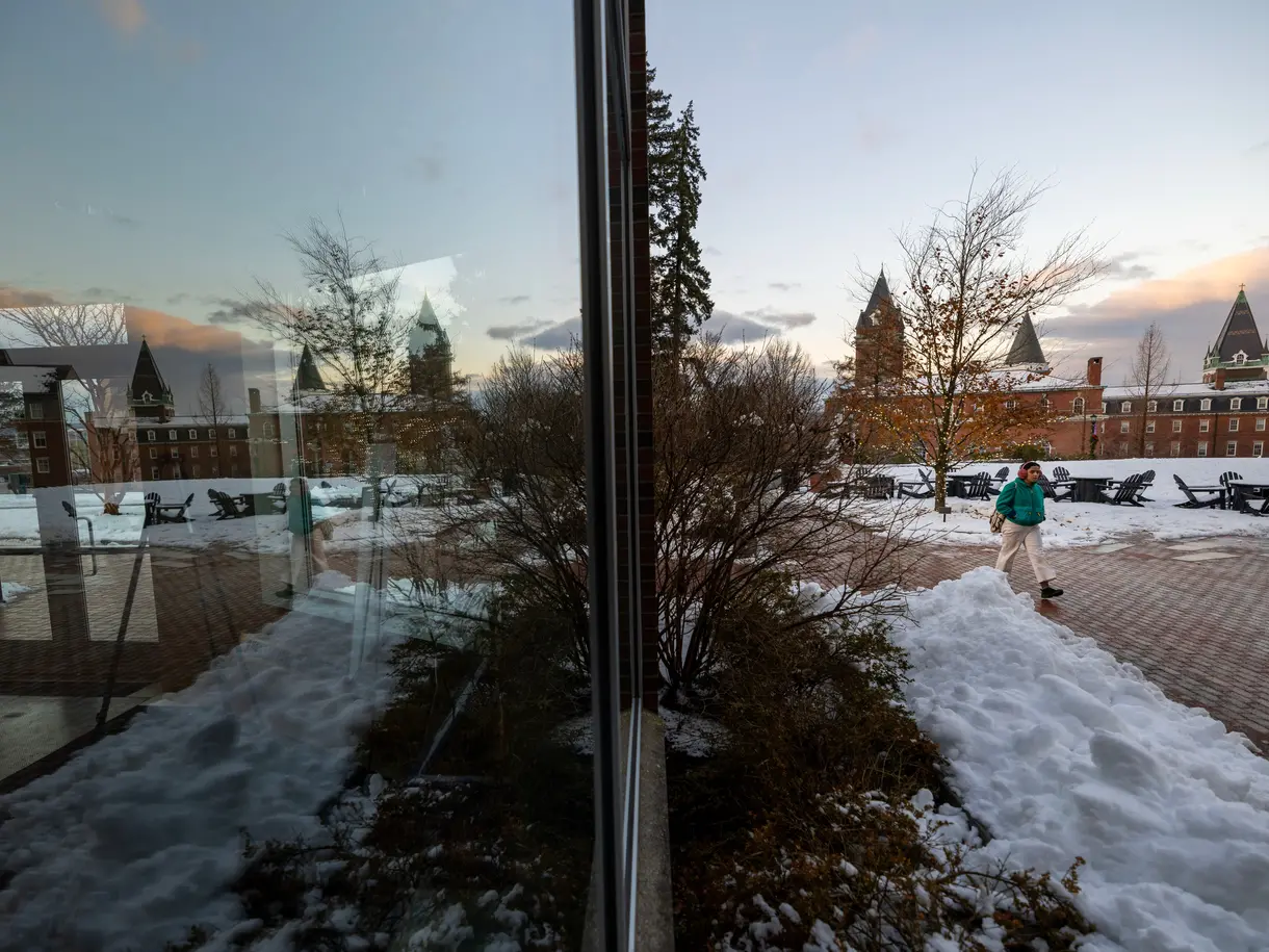 Reflection of student walking on campus in winter