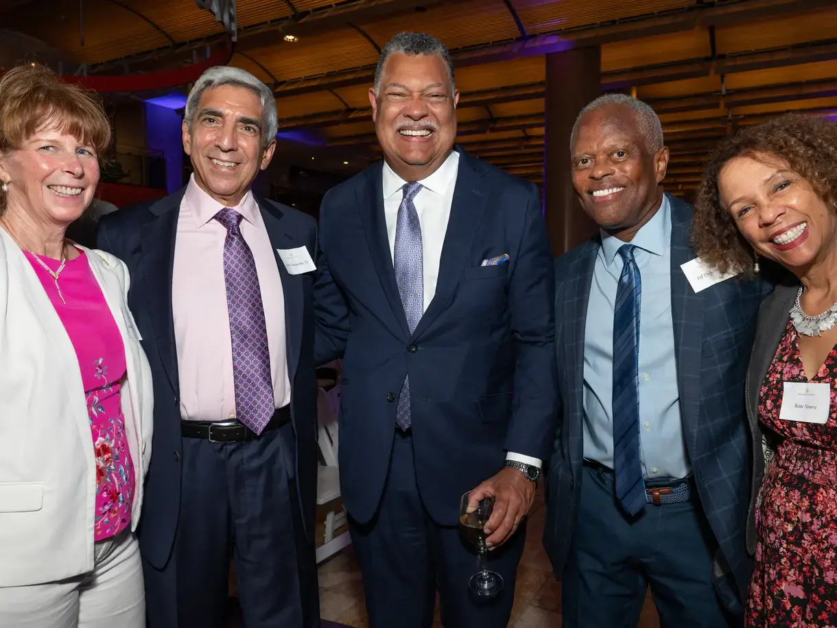 5 people in formal attire smiling at the camera