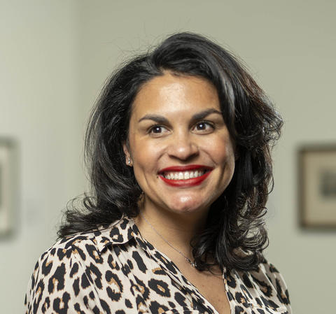 Rebecca VanDiver, wearing an animal print patterned shirt, smiles into the camera.