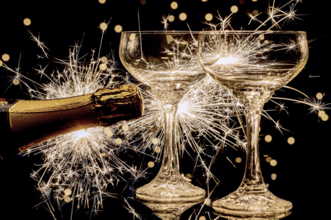 Fireworks, champagne bottle, two glasses.