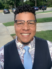 man in a collared shirt, tie and vest