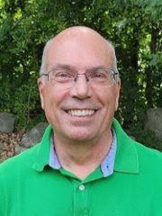 man with glasses in a green polo