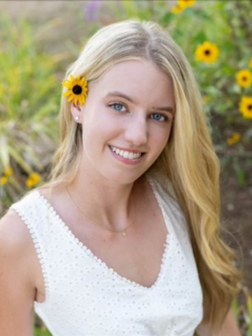 young woman in a white shirt with a flower behind her ear