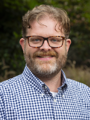 man in a blue checkered shirt wearing glasses